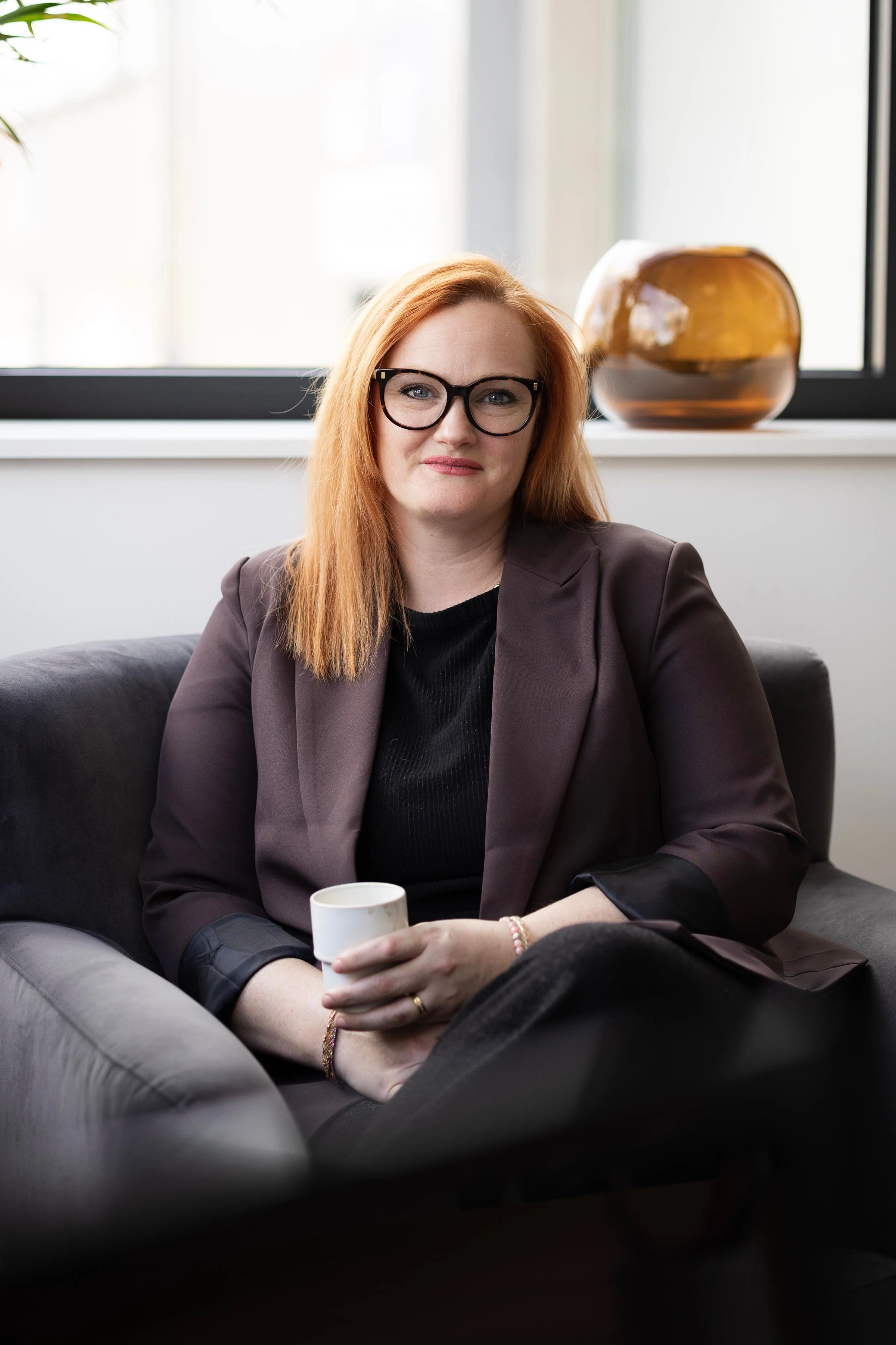 Laura assise dans un fauteuil, un carnet à la main